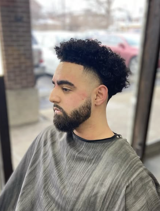 Curly top with skin fade and beard
